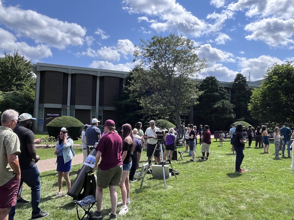 People and telescopes of different sizes on the grass