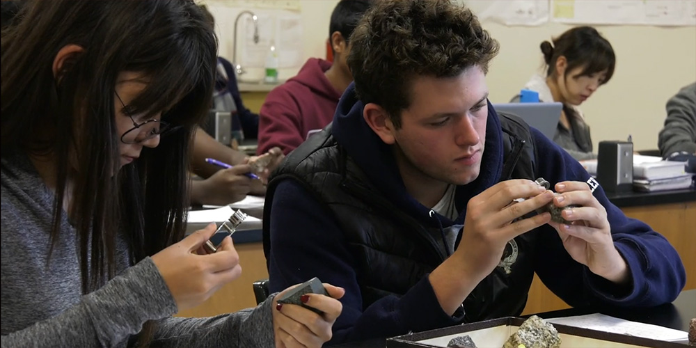 Students closely examining rocks.